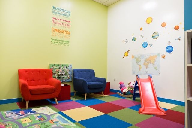 a living room with furniture and a baby crib