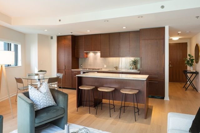 a kitchen with a dining table chairs and refrigerator