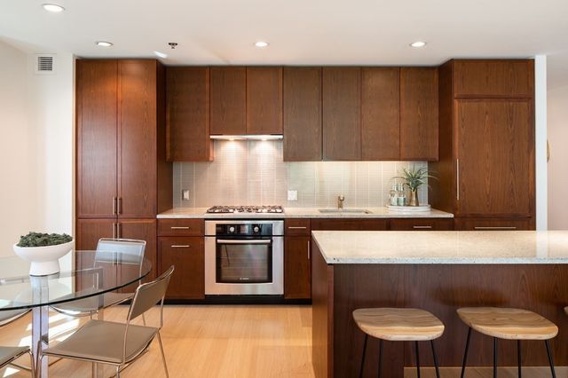a kitchen with stainless steel appliances granite countertop a stove a sink and a microwave