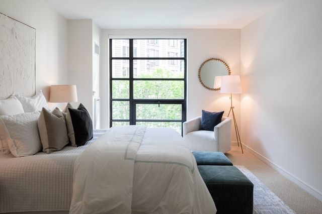 a bedroom with bed and a large window