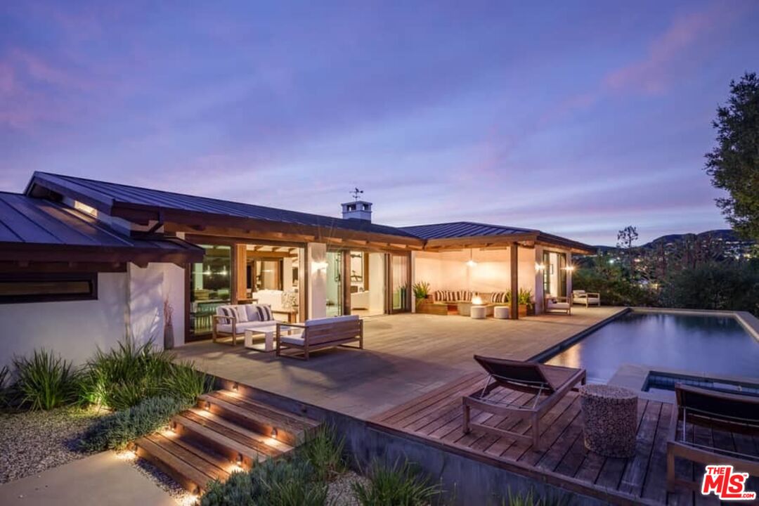 a view of a patio with table and chairs potted plants and wooden fence