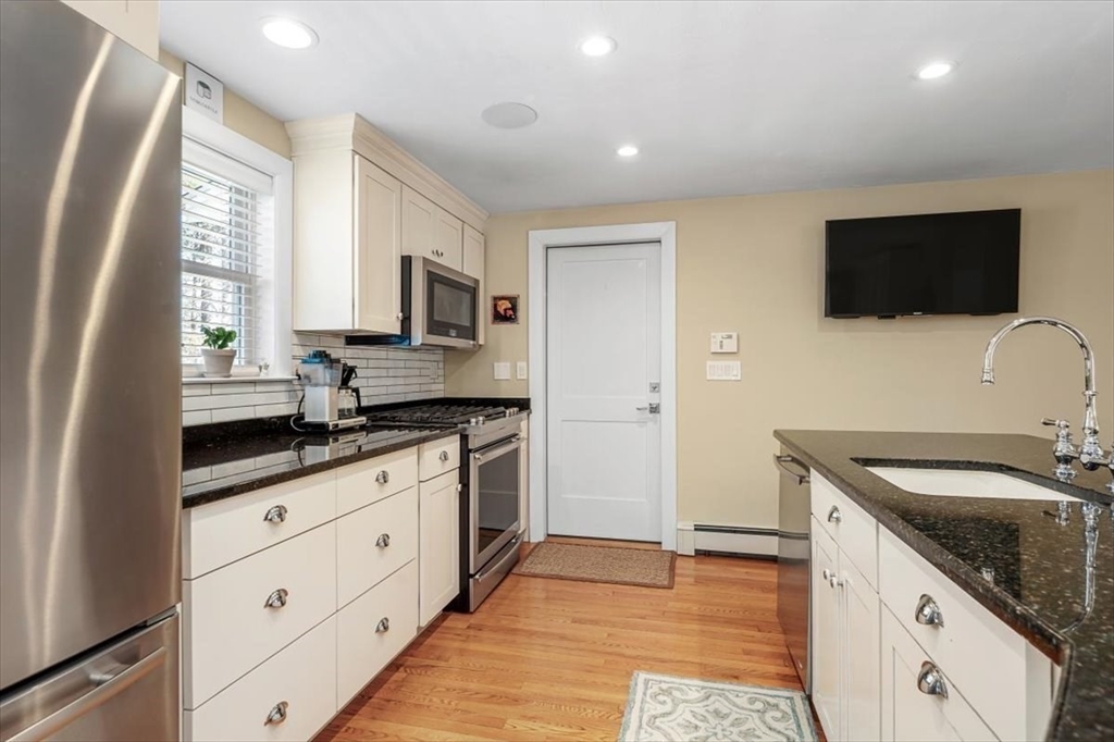 7 Peter Hobart Drive Hingham, MA 02043 - Photo 11 of 38 a kitchen with granite countertop a sink and a stove top oven with wooden floor