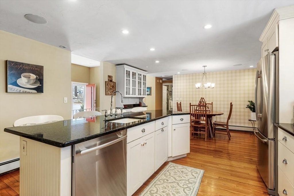 7 Peter Hobart Drive Hingham, MA 02043 - Photo 13 of 38 a kitchen with stainless steel appliances granite countertop a sink a stove a dining table and chairs