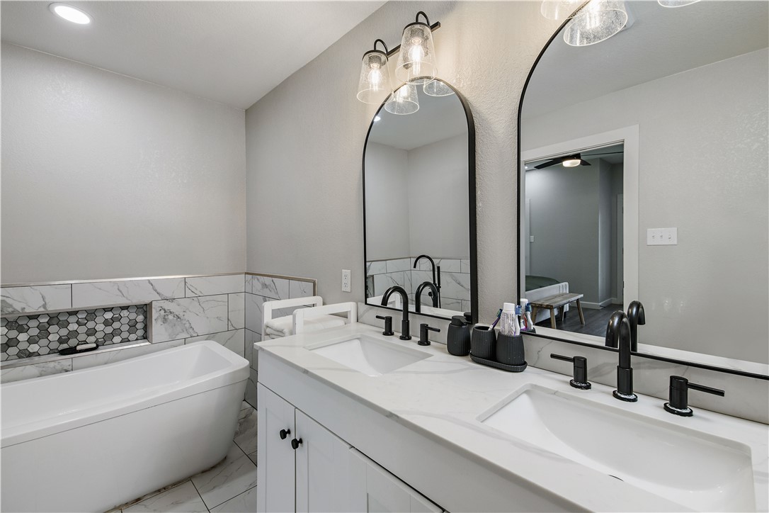 504 Eden Lane Bryan, TX 77803 - Photo 15 of 24 a bathroom with a double vanity sink mirror and bathtub