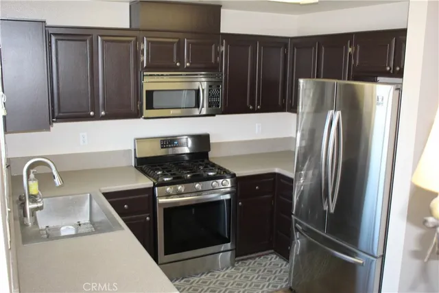 a kitchen with stainless steel appliances granite countertop a refrigerator stove and sink
