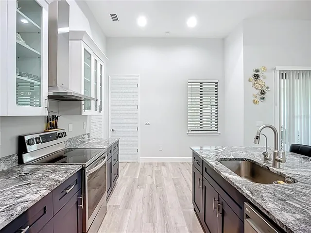 a kitchen with granite countertop a sink stove and cabinets
