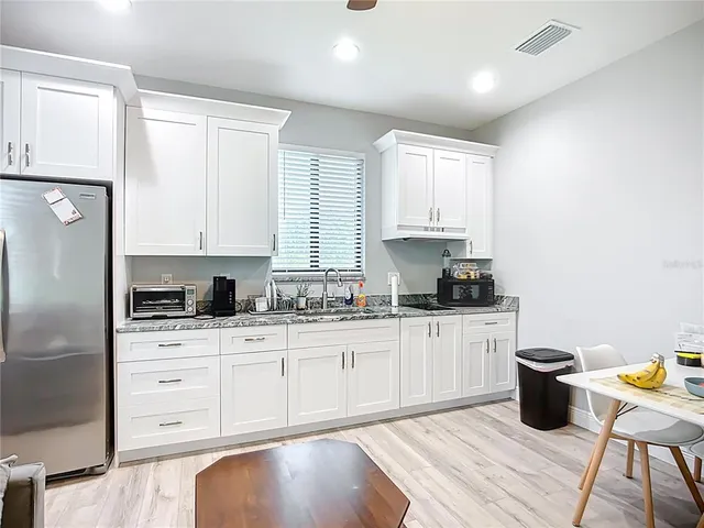 a kitchen with granite countertop white cabinets and white appliances
