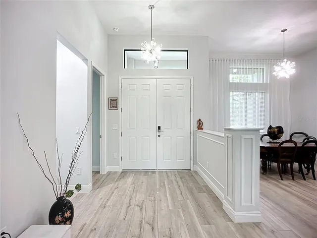 a view of a livingroom with furniture wooden floor windows and entryway