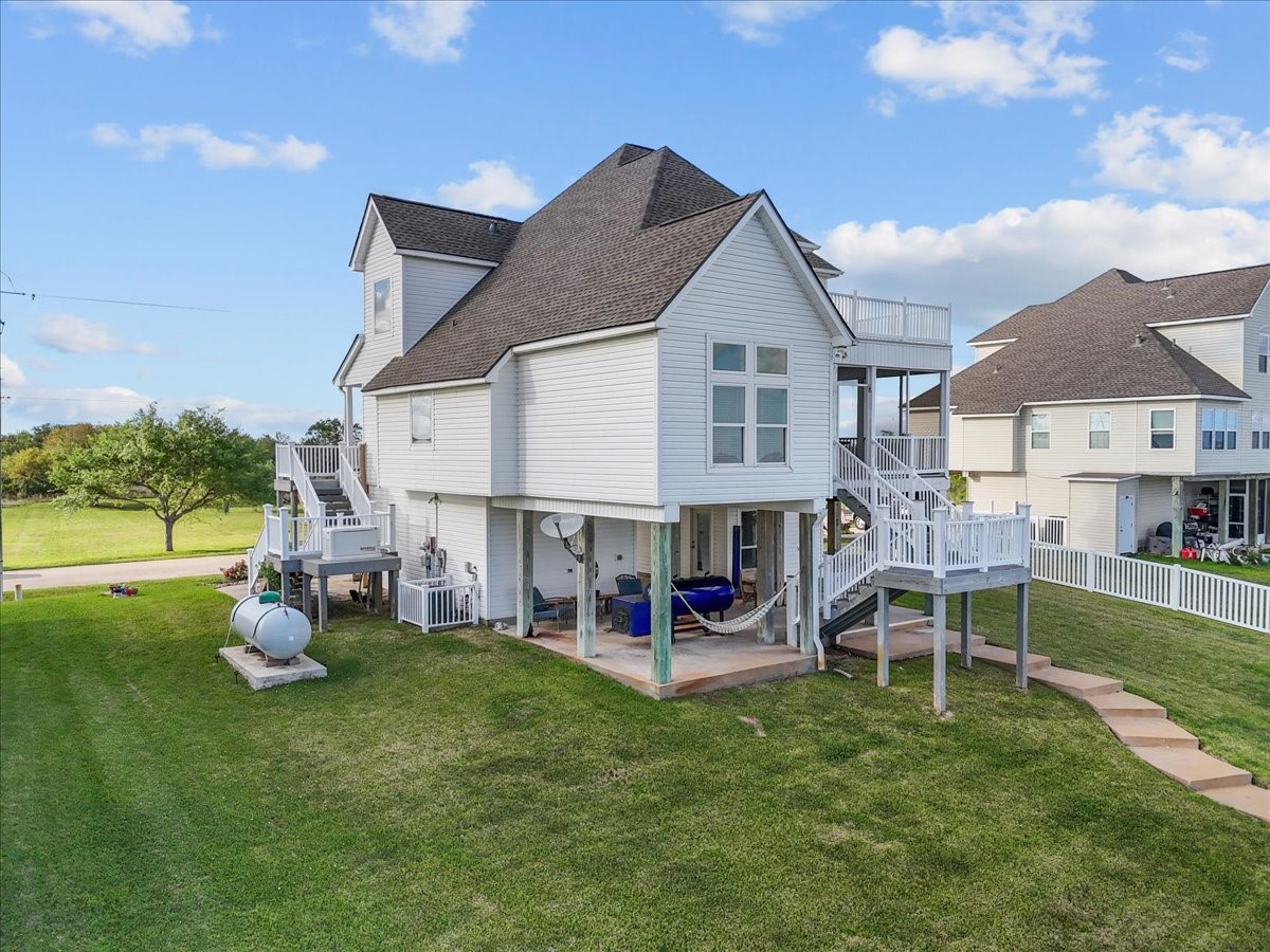211 Tuna Run Freeport, TX 77541 - Photo 10 of 48 This elevated home boasts a multi-level design with a spacious deck and large windows for natural light.
