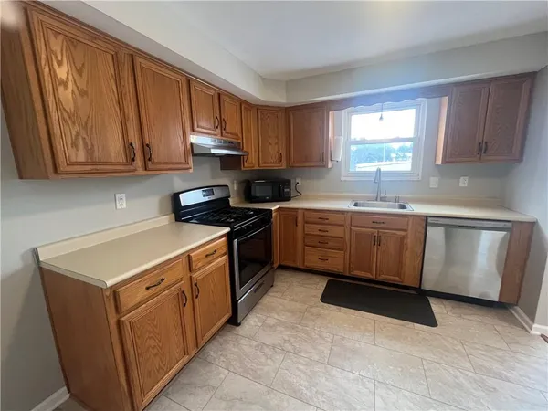 a kitchen with a sink stove top oven and cabinets