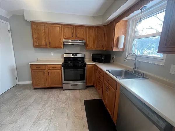a kitchen with stainless steel appliances a sink a stove a microwave a sink and cabinets