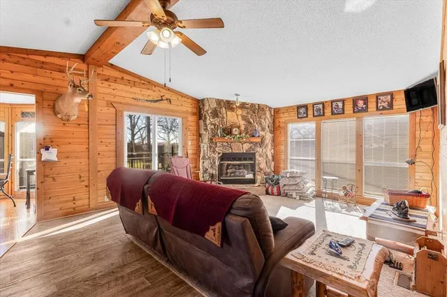 a living room with furniture a flat screen tv and a floor to ceiling window