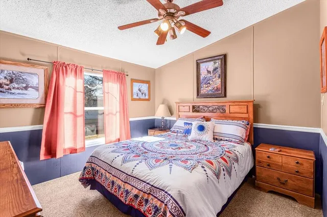 a bedroom with a bed and a dresser next to a window