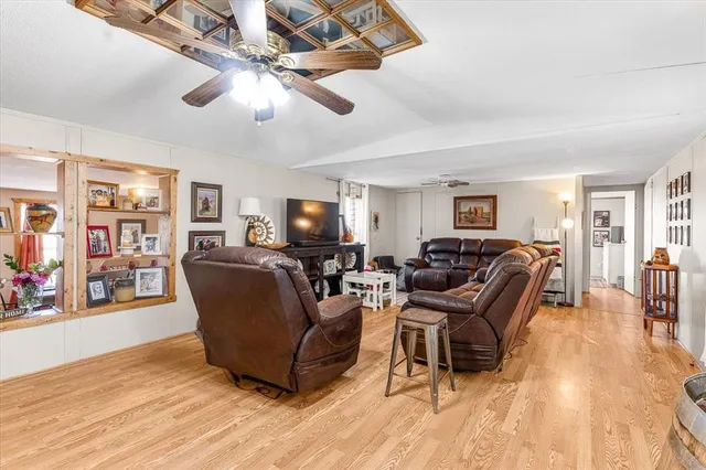 a living room with furniture a chandelier and a flat screen tv