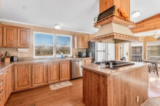 a kitchen with a stove a sink a window and cabinets