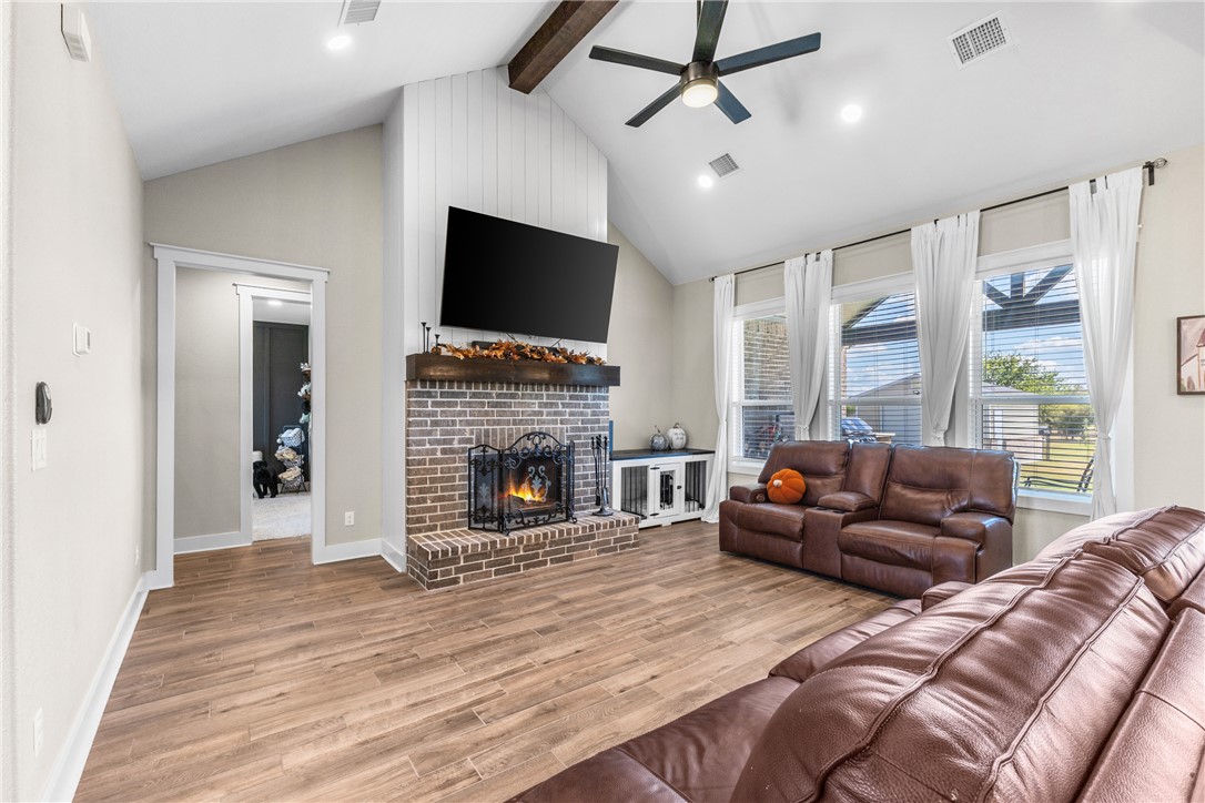 10356 Whiskey River Road Bryan, TX 77808 - Photo 12 of 39 a living room with furniture a flat screen tv and a fireplace