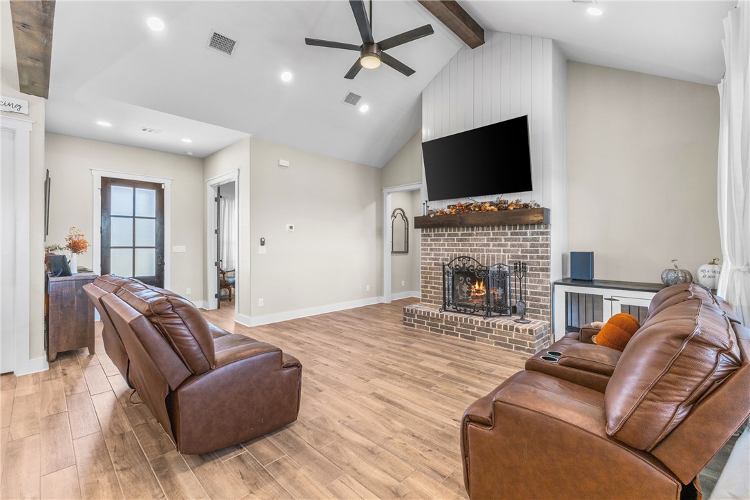 10356 Whiskey River Road Bryan, TX 77808 - Photo 13 of 39 a living room with furniture a flat screen tv and a fireplace