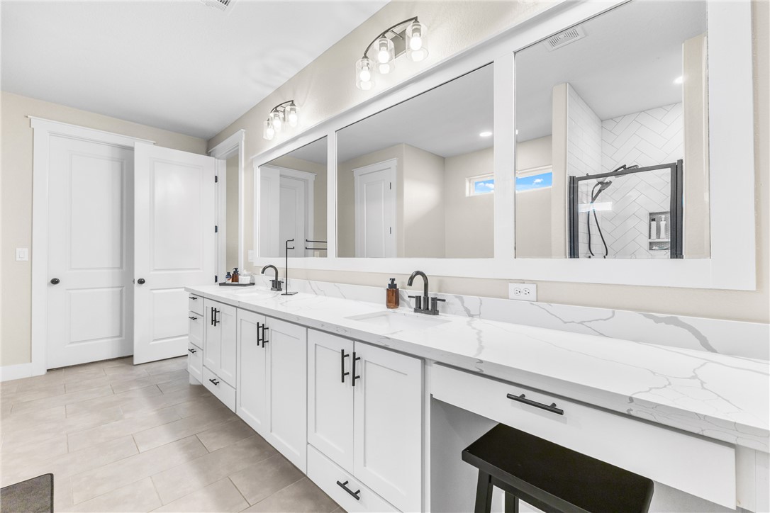 10356 Whiskey River Road Bryan, TX 77808 - Photo 23 of 39 a spacious bathroom with a double vanity sink and a mirror