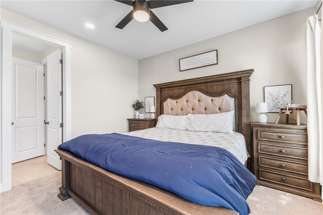 10356 Whiskey River Road Bryan, TX 77808 - Photo 25 of 39 a spacious bedroom with a bed and a chandelier