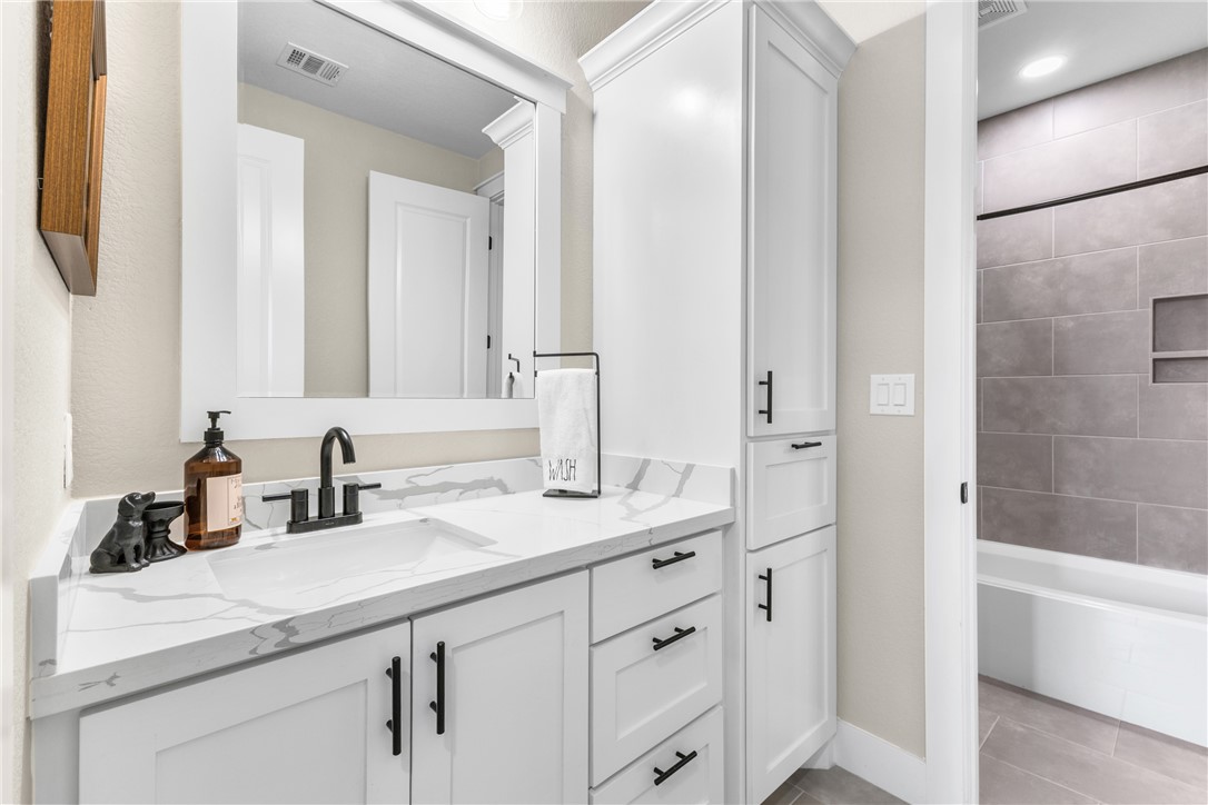 10356 Whiskey River Road Bryan, TX 77808 - Photo 28 of 39 a bathroom with a double vanity sink a mirror and a bathtub