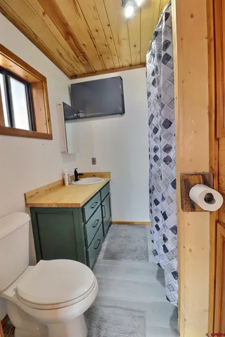 a utility room with a sink a toilet and vanity