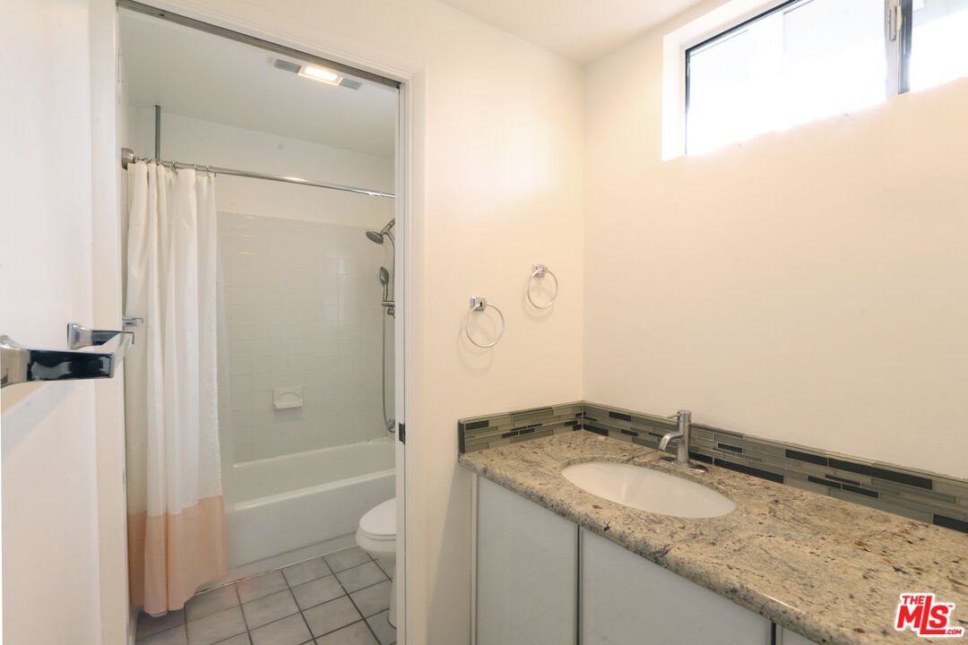 6557 Wandermere Road, Unit GH Malibu, CA 90265 - Photo 15 of 17 a bathroom with a granite countertop sink and a mirror