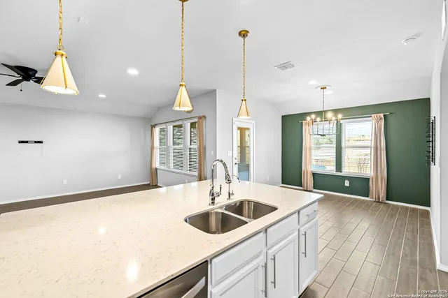 a kitchen with a sink a counter space and a ceiling fan