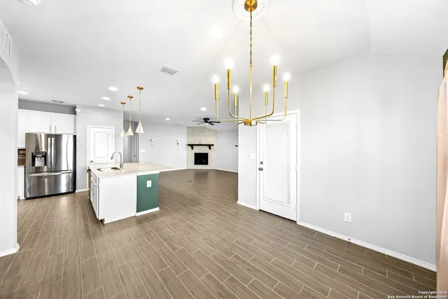 a view of a kitchen with refrigerator and wooden floor