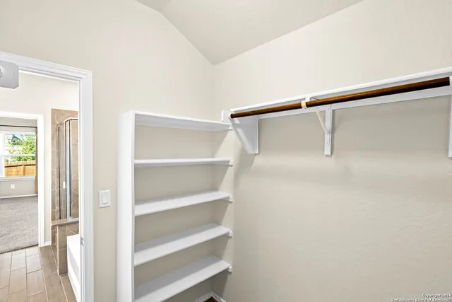 a view of walk in closet with empty racks