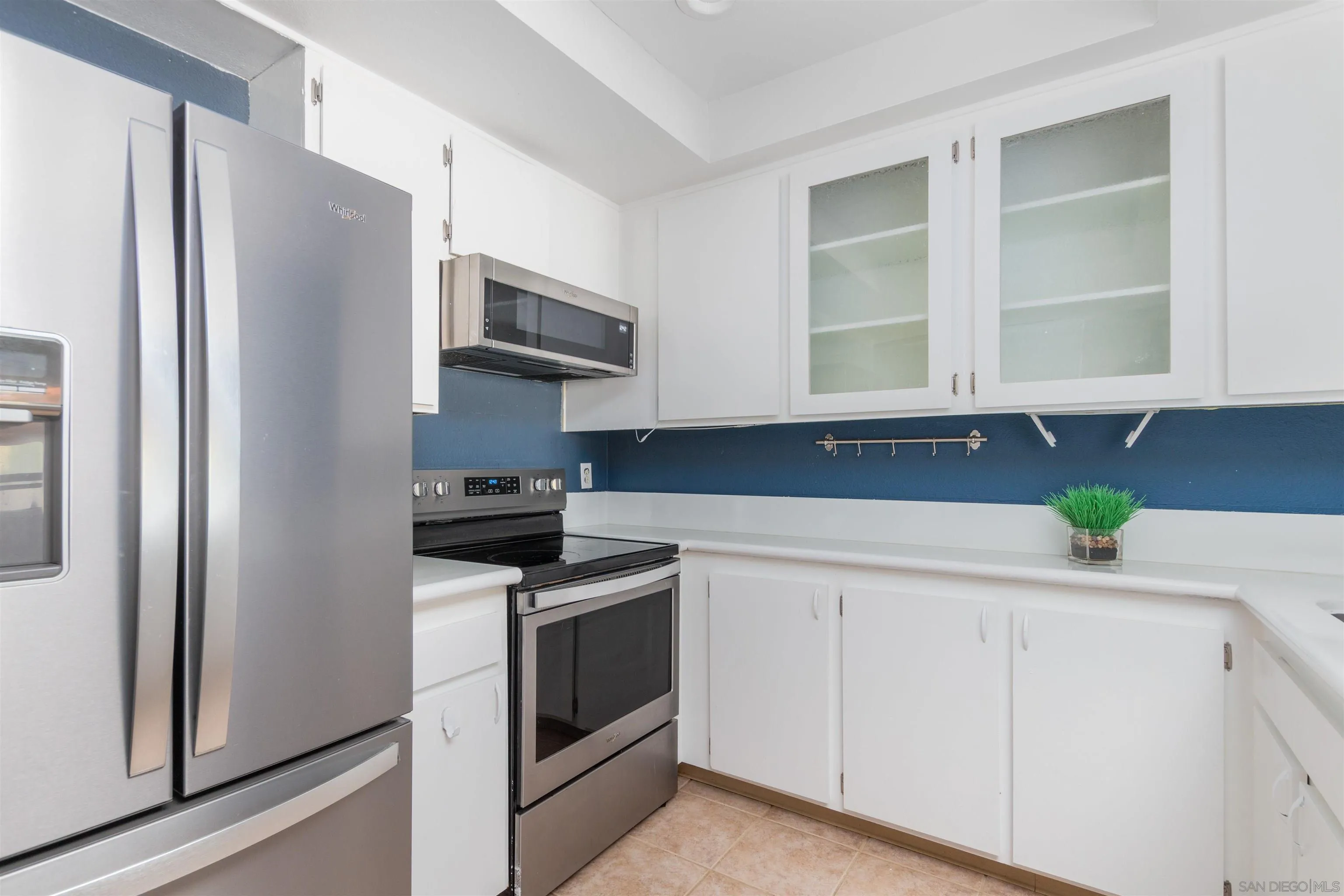 5922 Rancho Mission Road, Unit 67 San Diego, CA 92108 - Photo 4 of 19 a kitchen with granite countertop white cabinets and stainless steel appliances