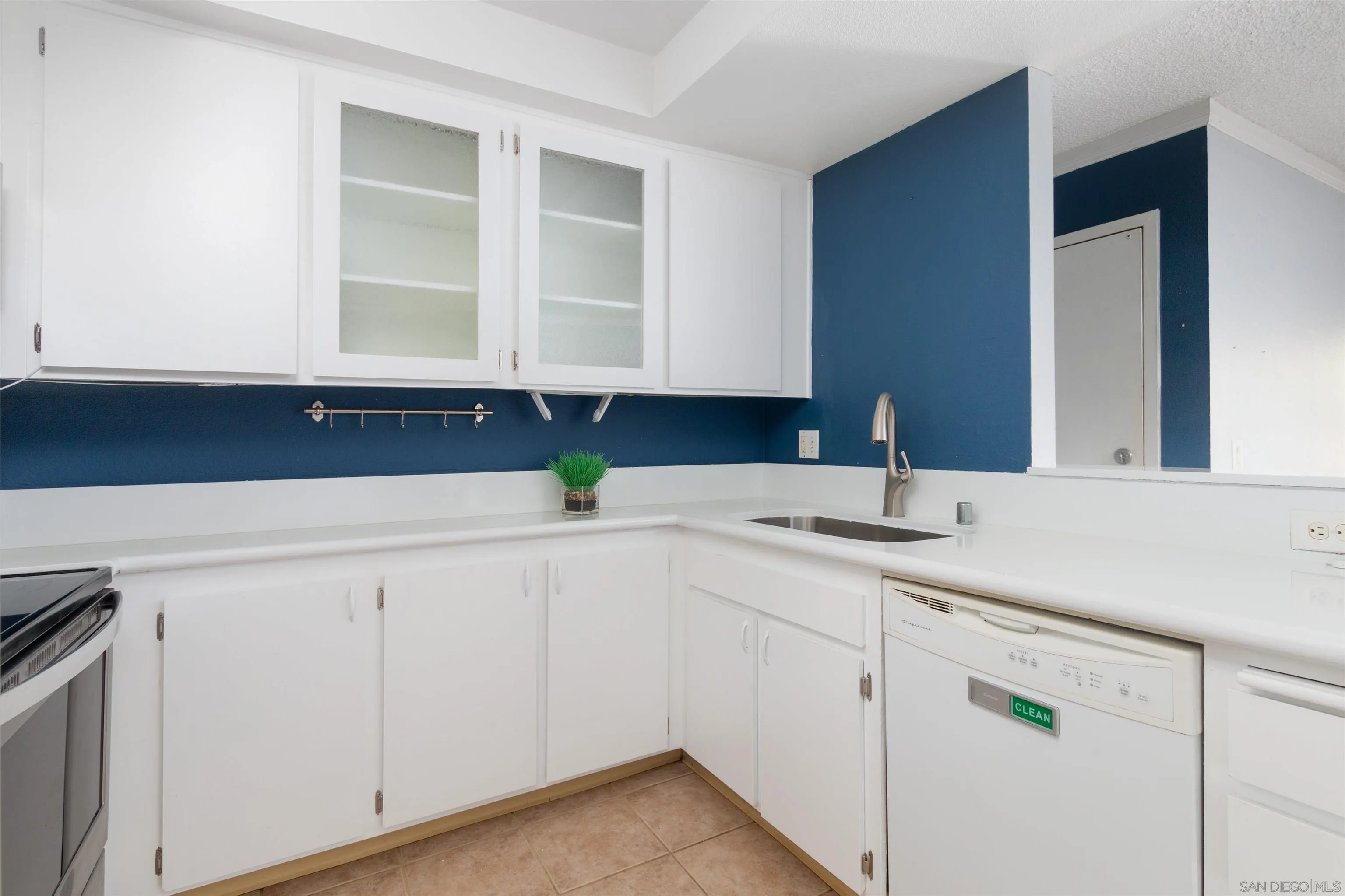 5922 Rancho Mission Road, Unit 67 San Diego, CA 92108 - Photo 6 of 19 a kitchen with white cabinets and sink