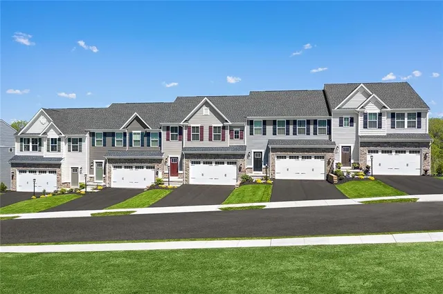 a front view of a residential houses with yard and green space