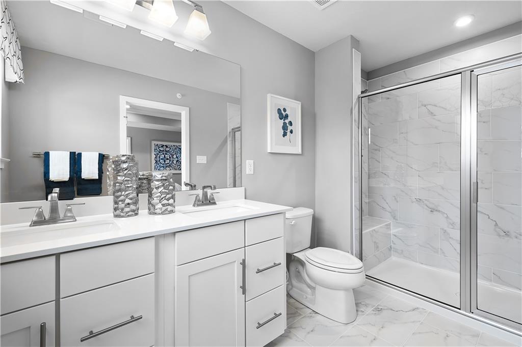 130 Olivia Drive Eighty Four, PA 15330 - Photo 18 of 27 a bathroom with a toilet a sink a mirror a shower a vanity and window