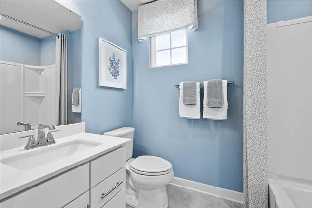 a bathroom with a toilet sink vanity and mirror