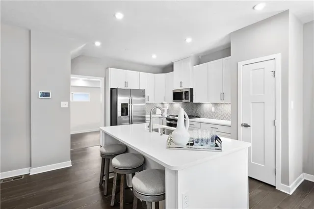 a view of kitchen with refrigerator a sink and chairs