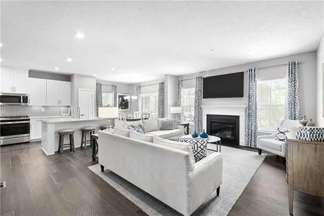 a living room with furniture a fireplace and a flat screen tv