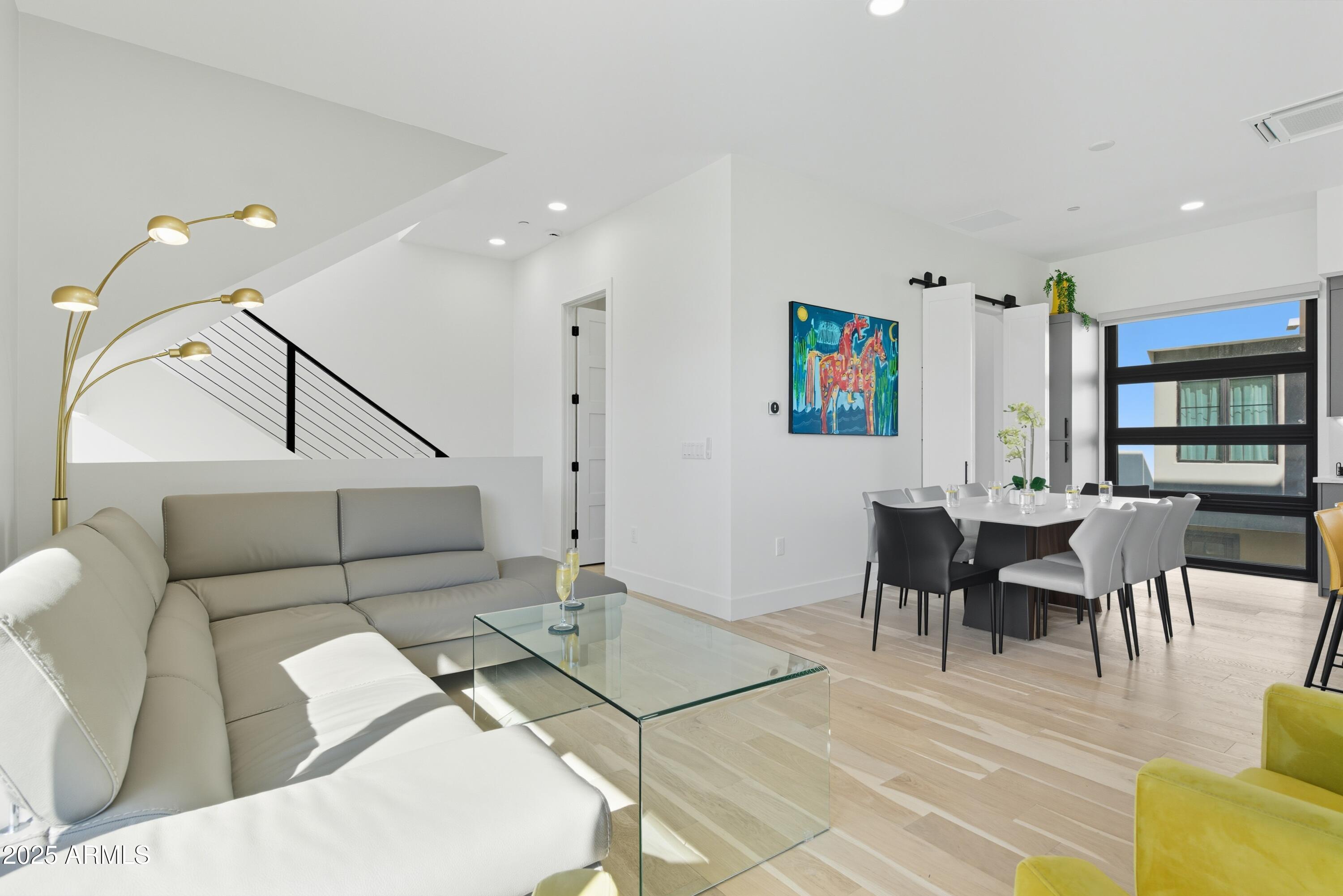 1501 North Miller Road, Unit 1015 Scottsdale, AZ 85257 - Photo 17 of 50 a living room with furniture and a dining table with wooden floor