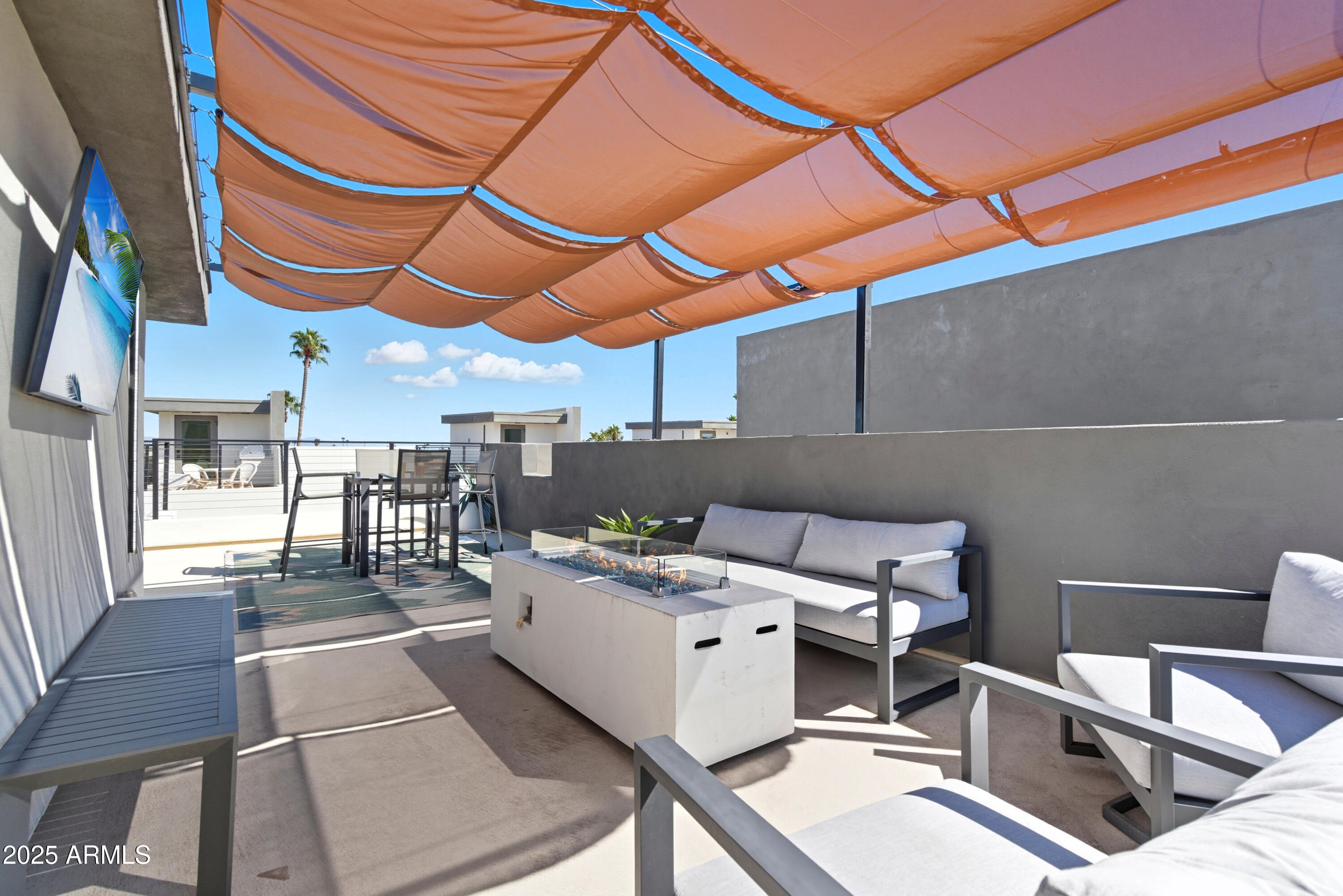 1501 North Miller Road, Unit 1015 Scottsdale, AZ 85257 - Photo 46 of 50 a roof deck with table and chairs under an umbrella