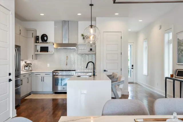 a kitchen with kitchen island stainless steel appliances a sink a stove a refrigerator and cabinets