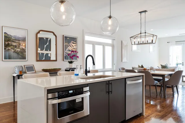 a kitchen with stainless steel appliances granite countertop a sink a stove and chairs