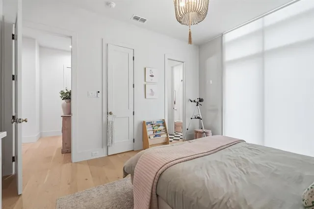 a bedroom with a bed and a chandelier