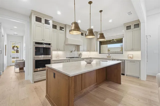 a kitchen with stainless steel appliances granite countertop a sink a stove and a refrigerator