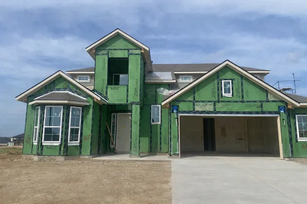 a front view of a house with a yard and plants