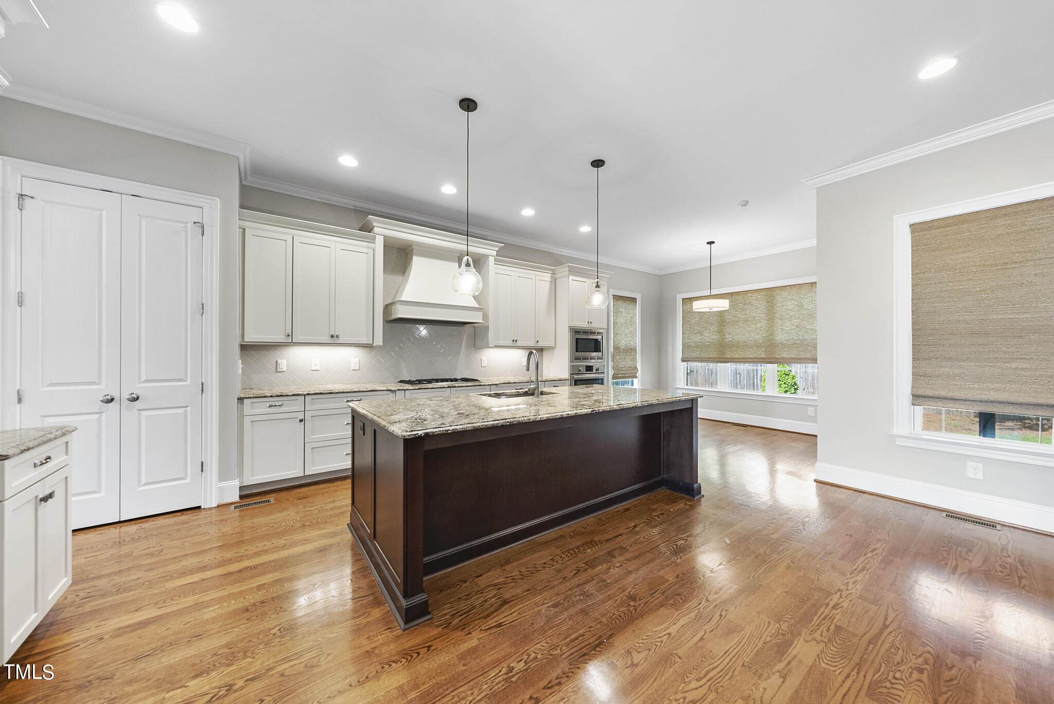 6411 Rosny Road Raleigh, NC 27613 - Photo 14 of 30 a large kitchen with stainless steel appliances granite countertop a stove and a wooden floors