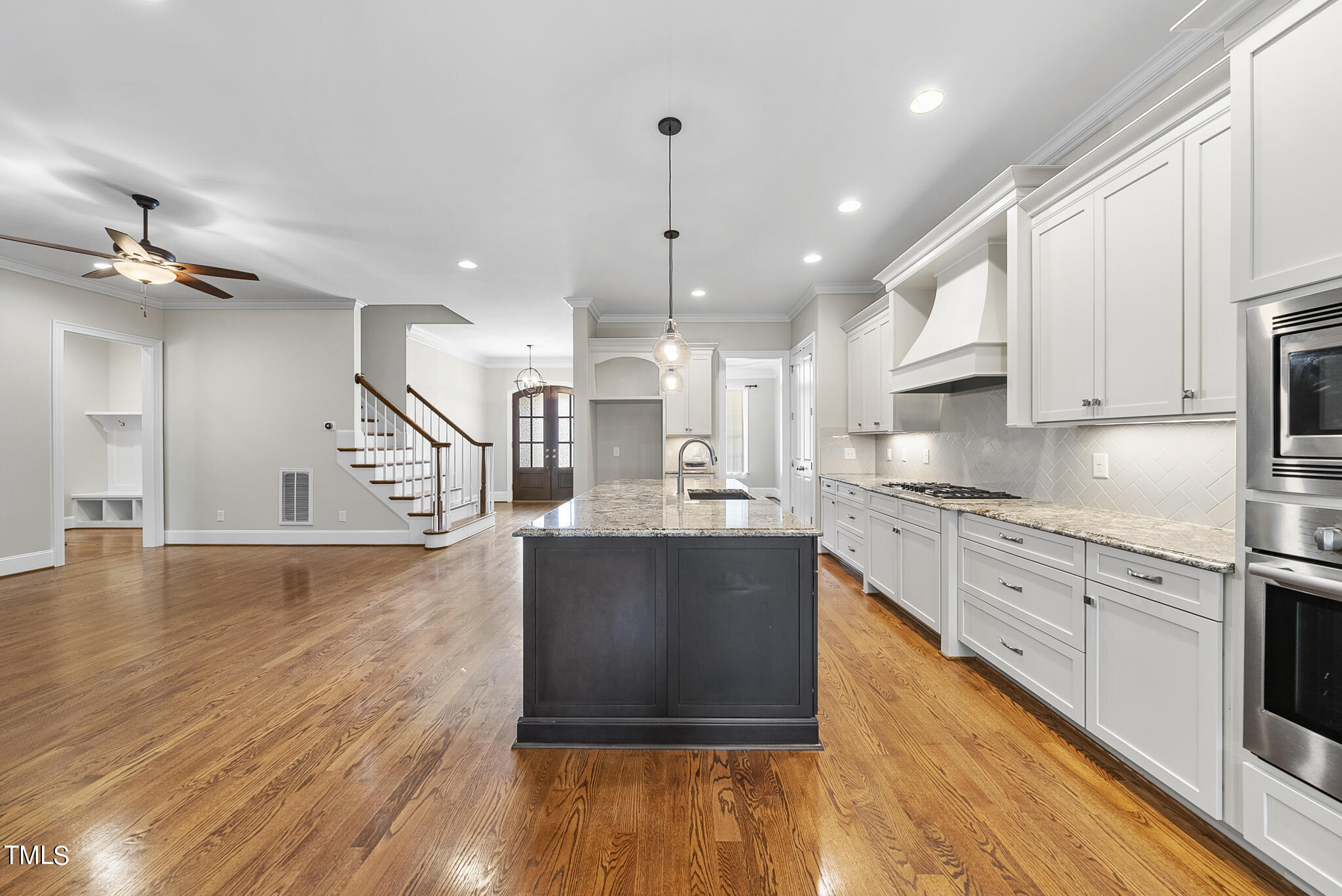 6411 Rosny Road Raleigh, NC 27613 - Photo 16 of 30 a large kitchen with stainless steel appliances granite countertop a stove and a wooden floors