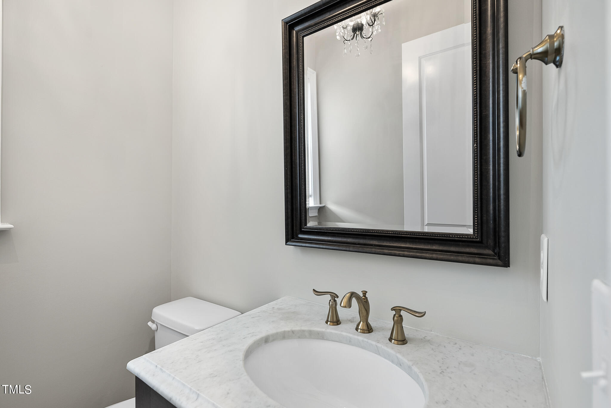 6411 Rosny Road Raleigh, NC 27613 - Photo 22 of 30 a bathroom with a sink a mirror and a toilet
