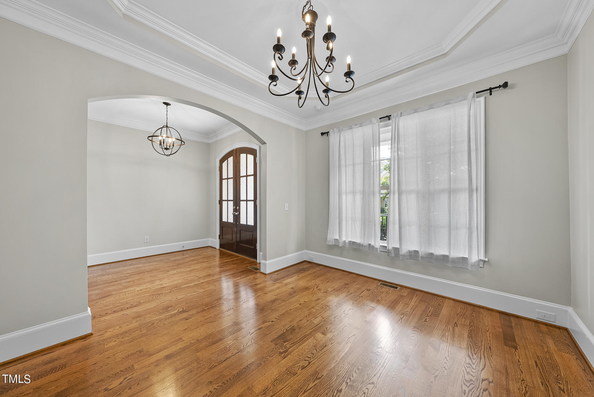 6411 Rosny Road Raleigh, NC 27613 - Photo 6 of 30 a view of an empty room with wooden floor and a window