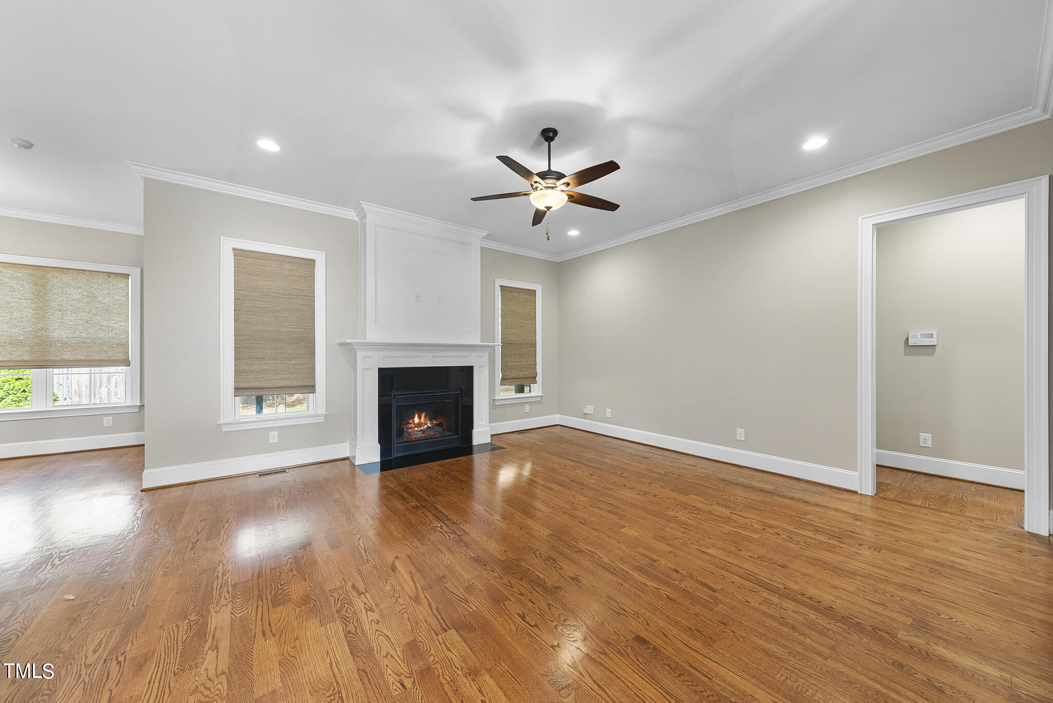 6411 Rosny Road Raleigh, NC 27613 - Photo 7 of 30 an empty room with wooden floor and a fireplace