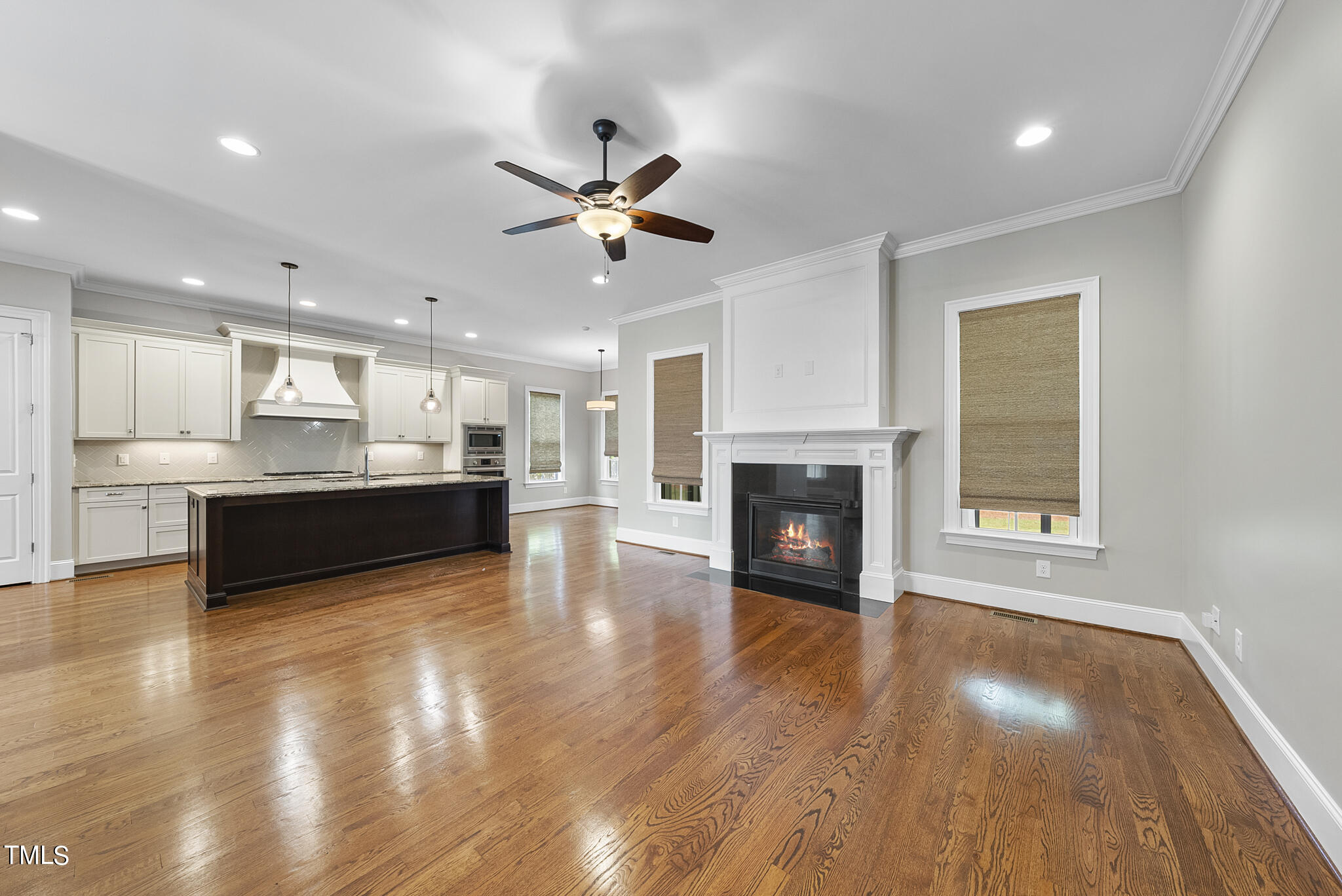 6411 Rosny Road Raleigh, NC 27613 - Photo 9 of 30 a view of kitchen and hall with wooden floor and a fireplace
