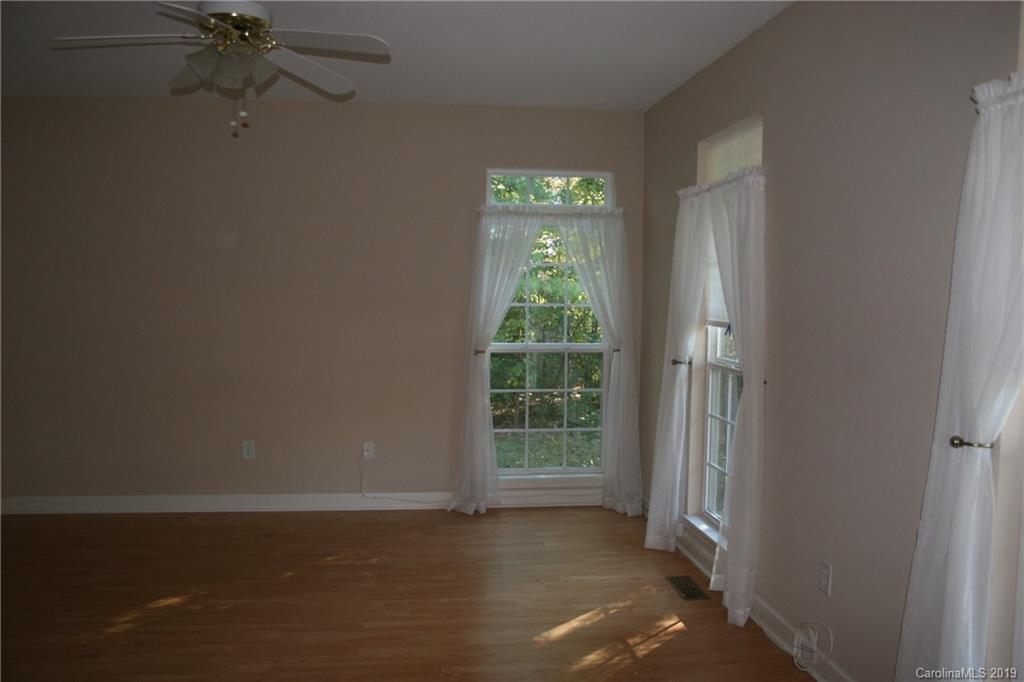 805 Stratford Road Troutman, NC 28166 - Photo 29 of 34 a view of a room with wooden floor a ceiling fan and a window